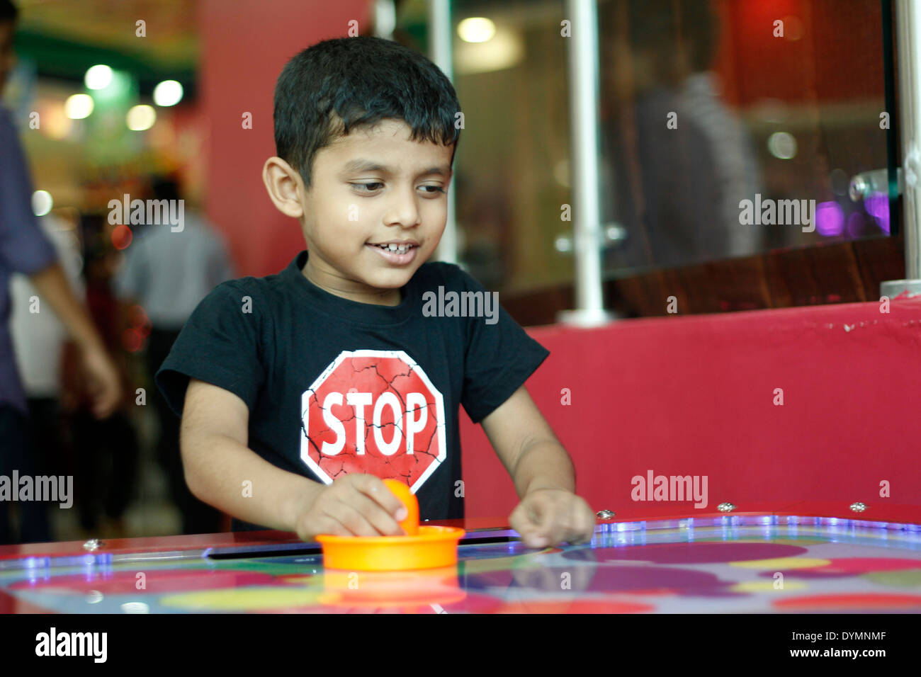 Indian toddler playing air hockey Stock Photo