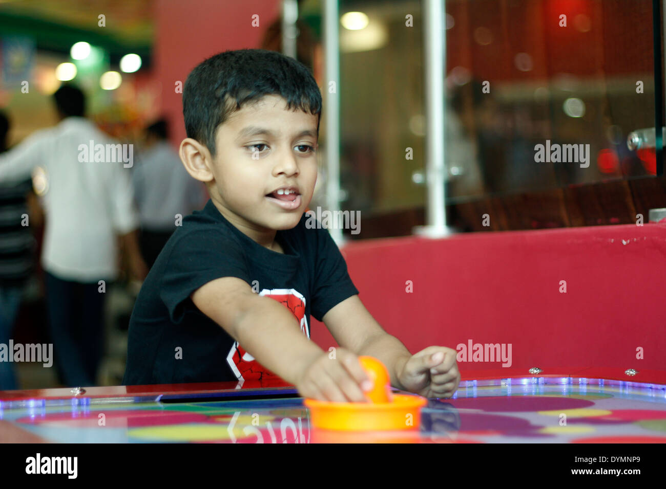 Indian toddler playing air hockey Stock Photo