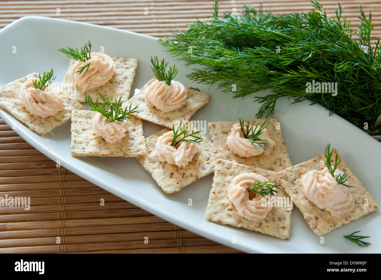 Salmon pate on multigrain crackers with dill Stock Photo