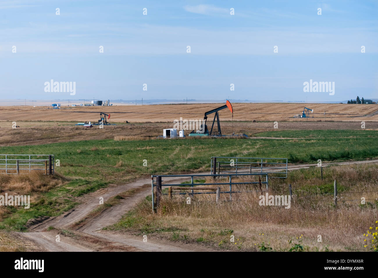 Prairie farm with three oil pumpjacks Stock Photo