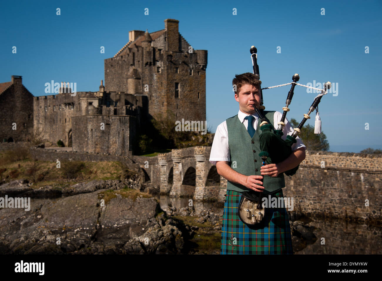 Bagpipe player with Eilean Donan Castle in background, Scotland, Uk Stock Photo