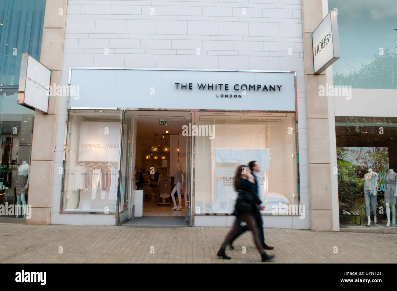 Shoppers walk past the shopfront of the lifestyle store The White Company in up-market Cabot Circus shopping area in Bristol Stock Photo