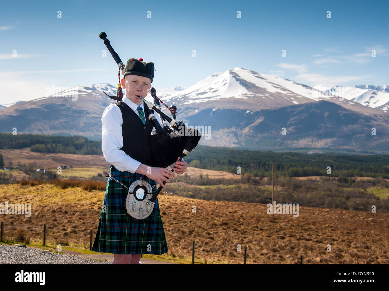 Bagpipe player with Ben Nevis mountain range in background, Scotland, UK Stock Photo