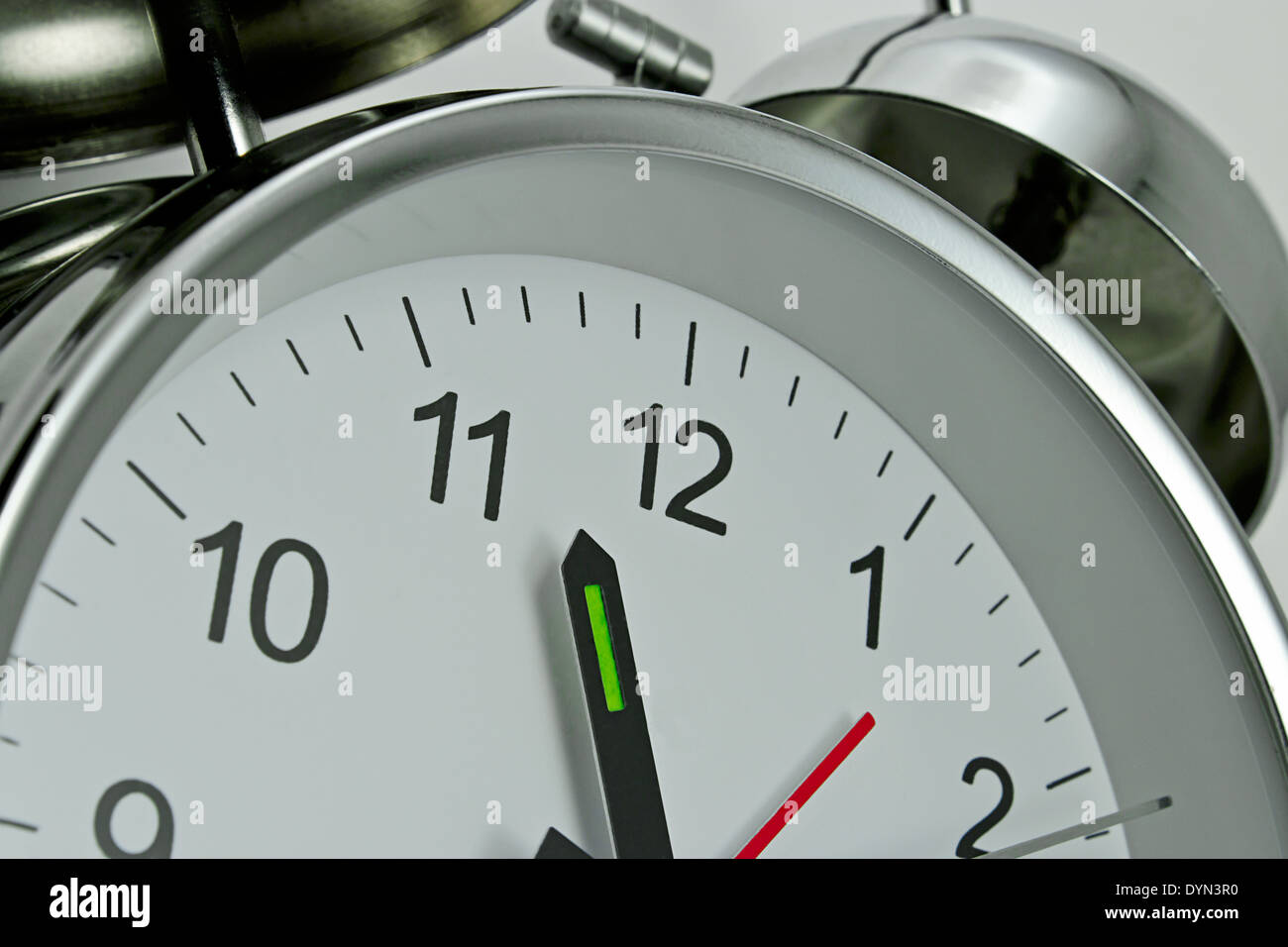 Close up of a Clockface on a traditional chrome silver Alarm clock with bells on the top Stock Photo