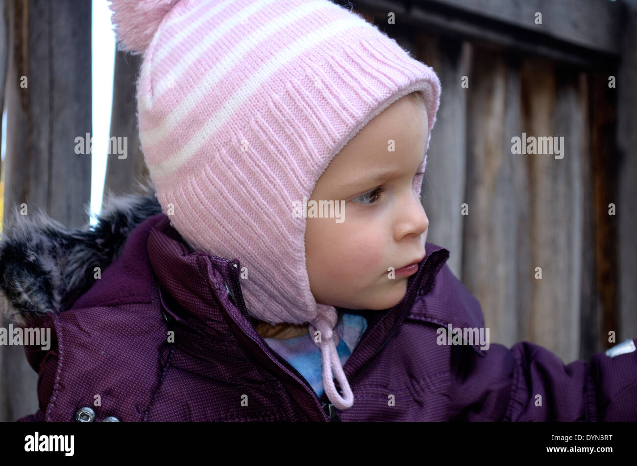 Little girl profile in pink hat with ear flaps Stock Photo