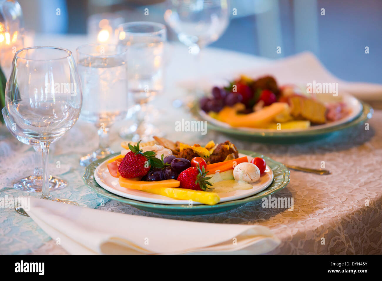 Wedding food at the reception includes dinner on a plate at a table. Stock Photo