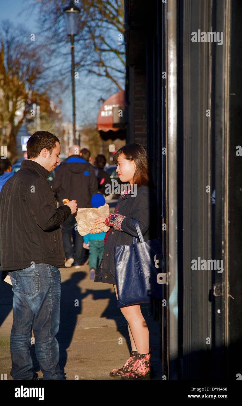 Couple share sandwich, Portobello Road market, London, England, UK Stock Photo