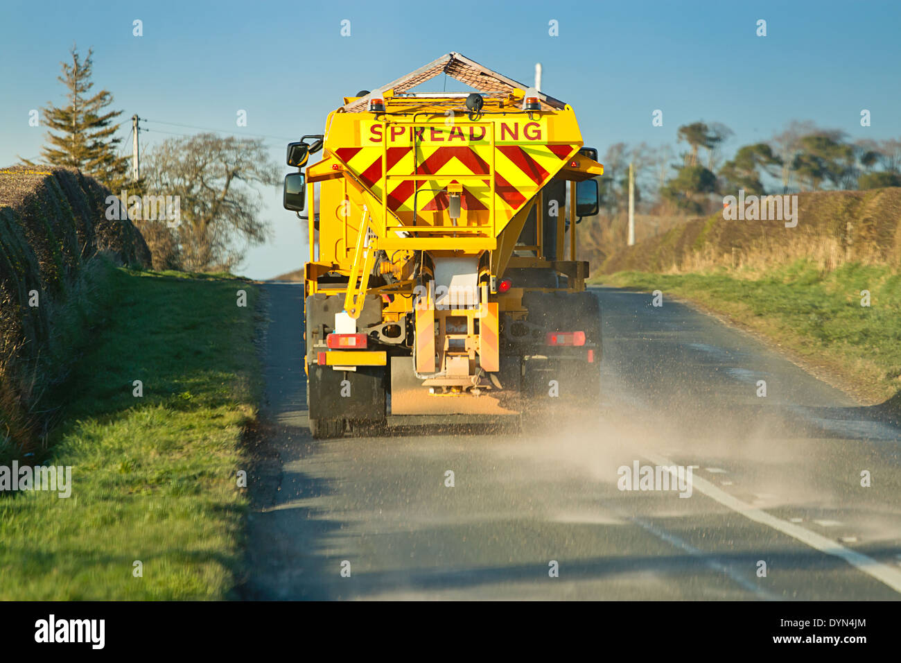 Gritter spreading salt on country roads to stop ice forming on a winters night and dangerous driving conditions. Stock Photo