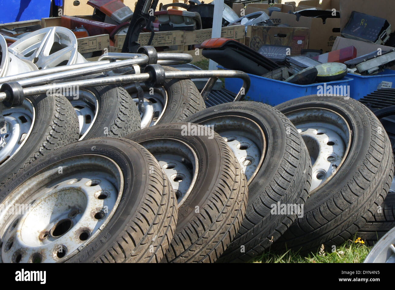 spare tires and car parts at an outdoor flea market in Normandy, France