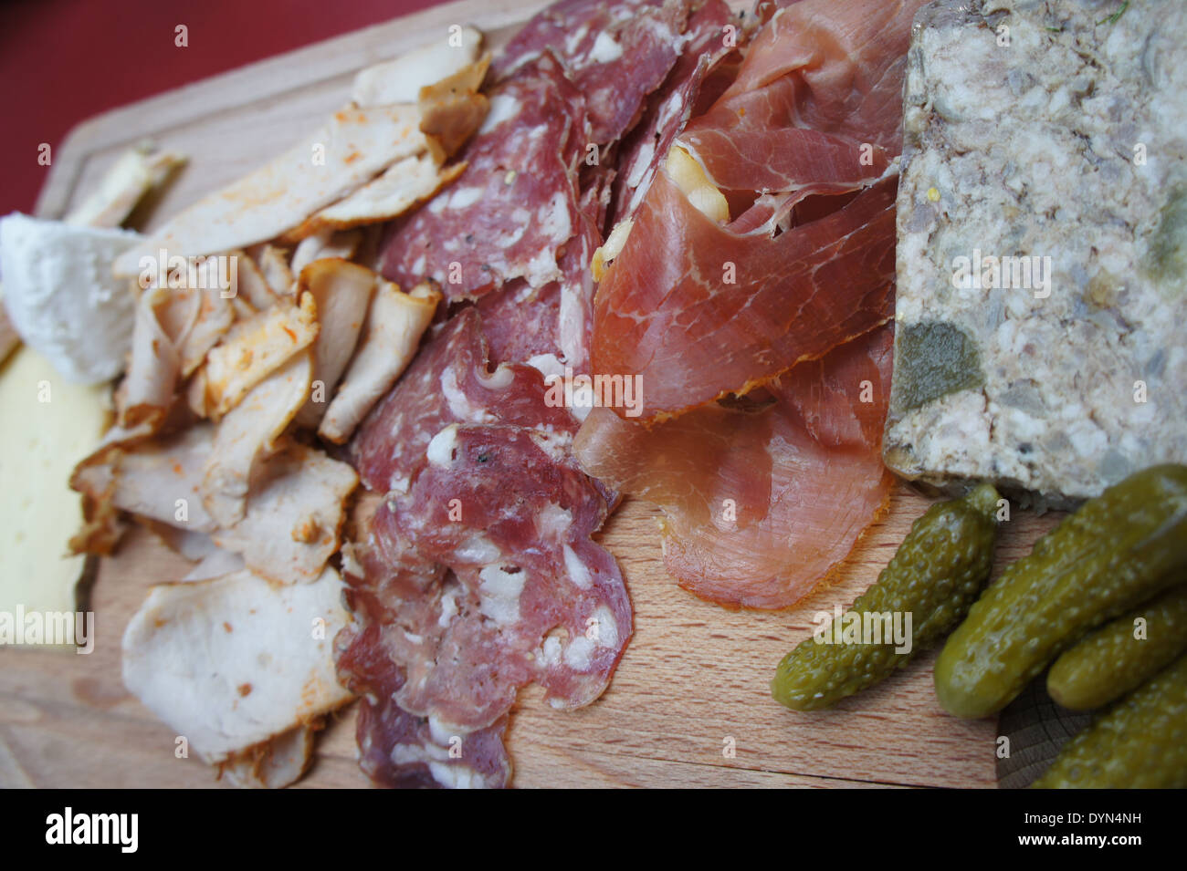Charcuterie plate with salami, cheese, meat, pate, pickles on wooden cutting board Stock Photo