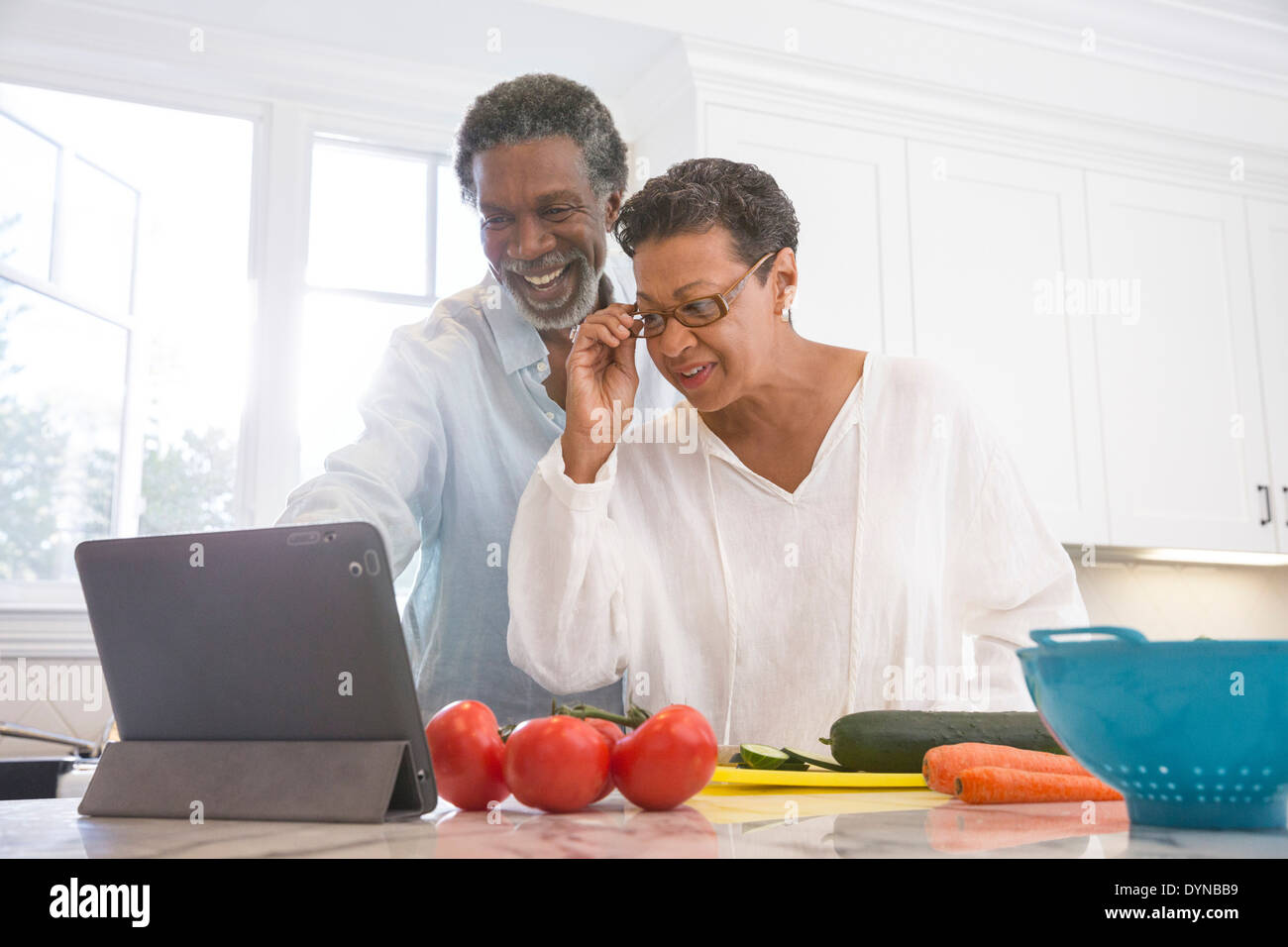 Senior couple using digital tablet in kitchen Stock Photo