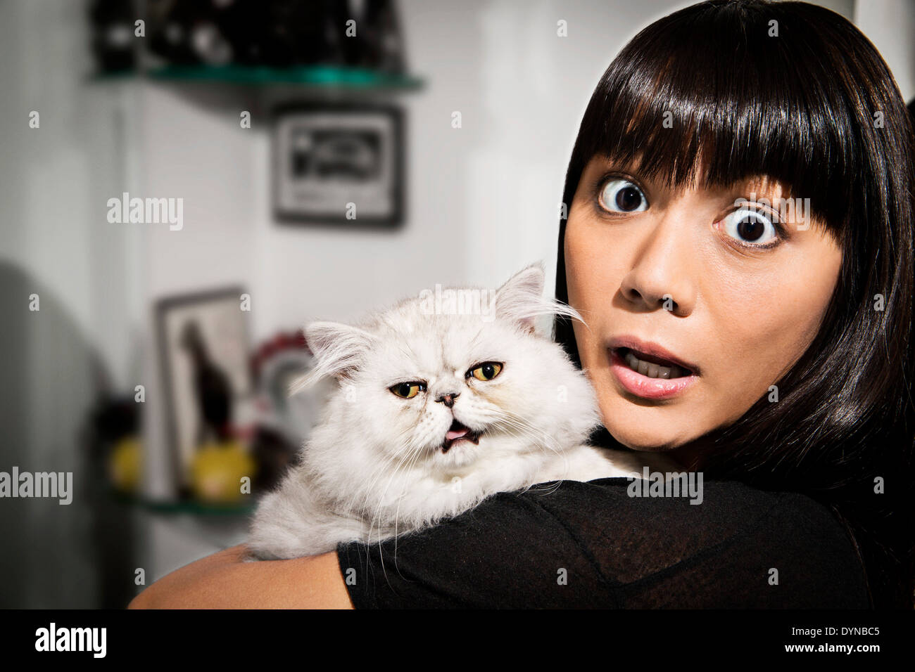 Surprised woman holding cat Stock Photo