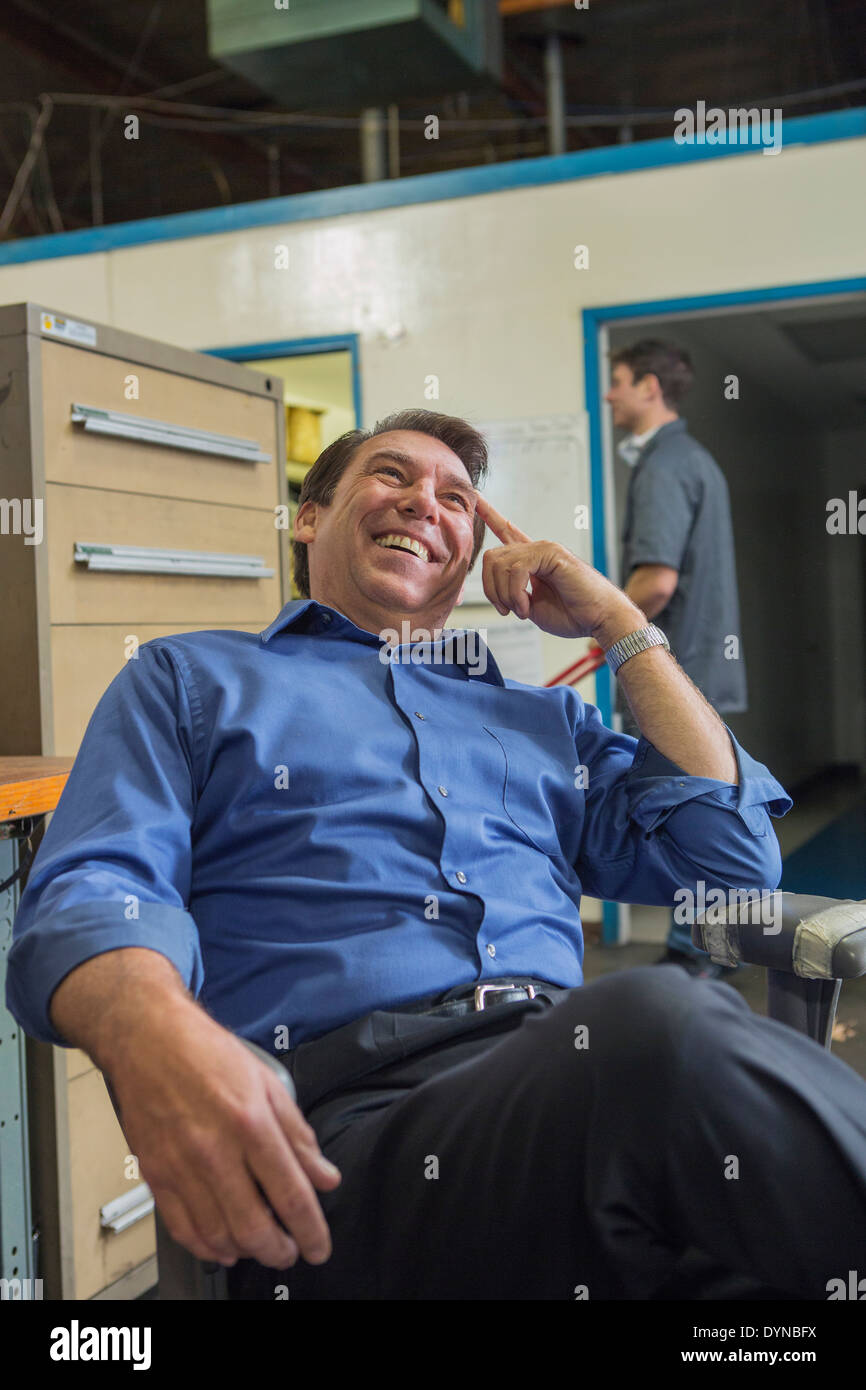 Caucasian manager laughing in warehouse Stock Photo