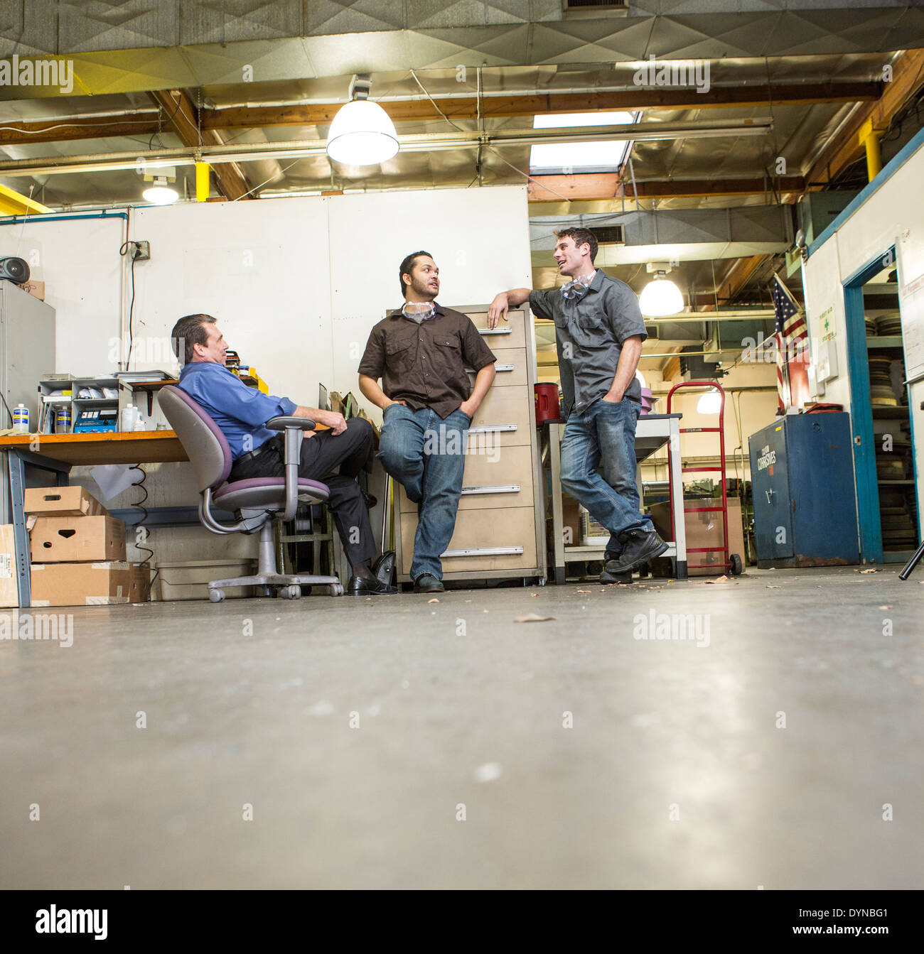 Manager and workers talking in warehouse Stock Photo