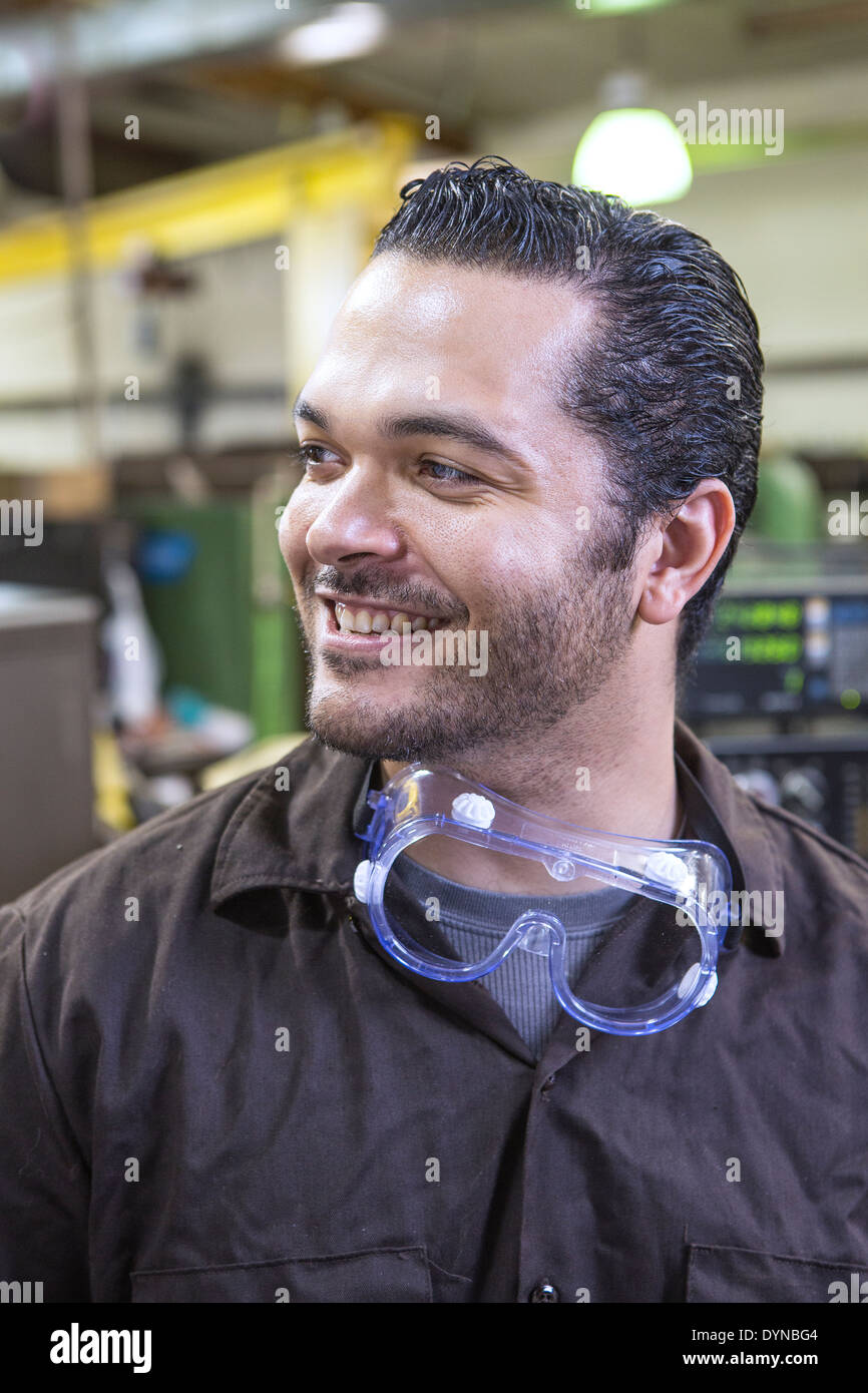 Hispanic worker smiling in warehouse Stock Photo