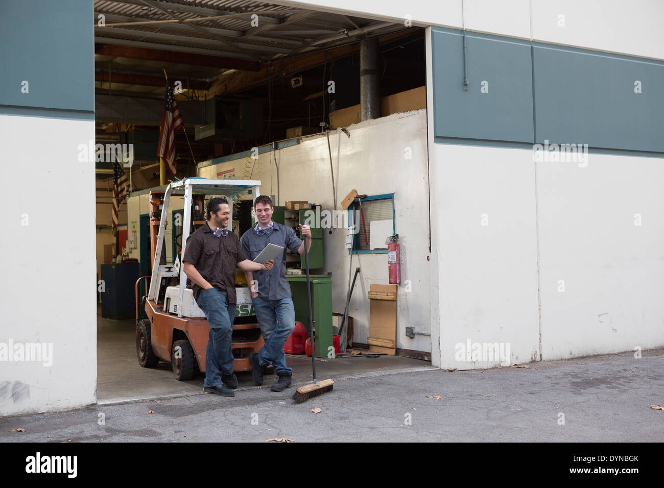 Workers using digital tablet at warehouse loading dock Stock Photo