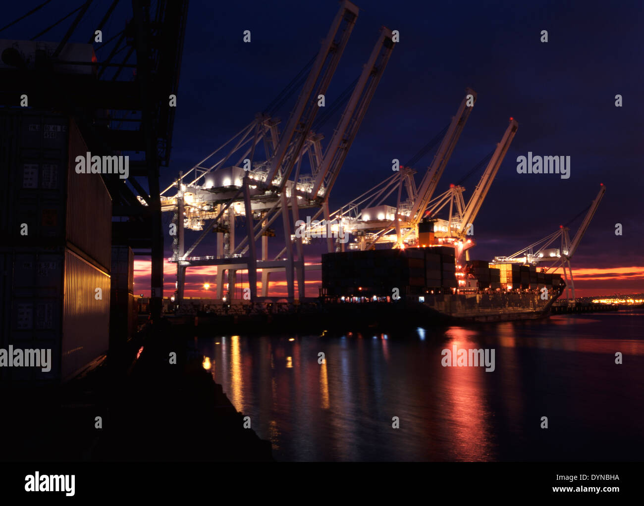 Illuminated cranes over commercial dock at night, Long Beach, California, United States Stock Photo