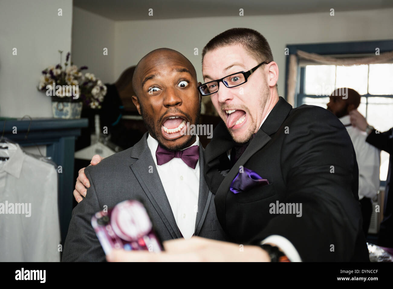 Groom and groomsman taking silly self-portrait Stock Photo