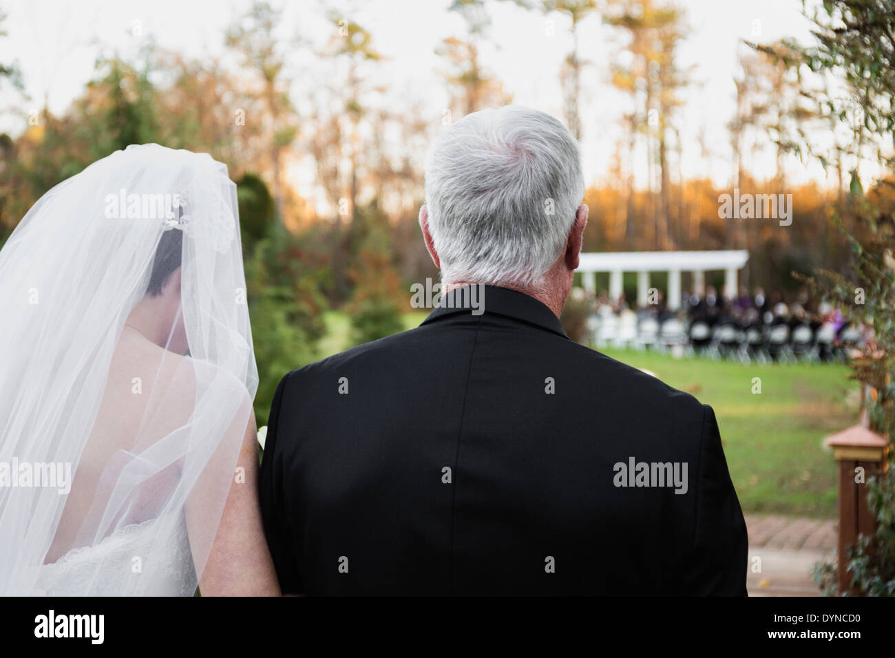 Caucasian father walking bride down aisle Stock Photo