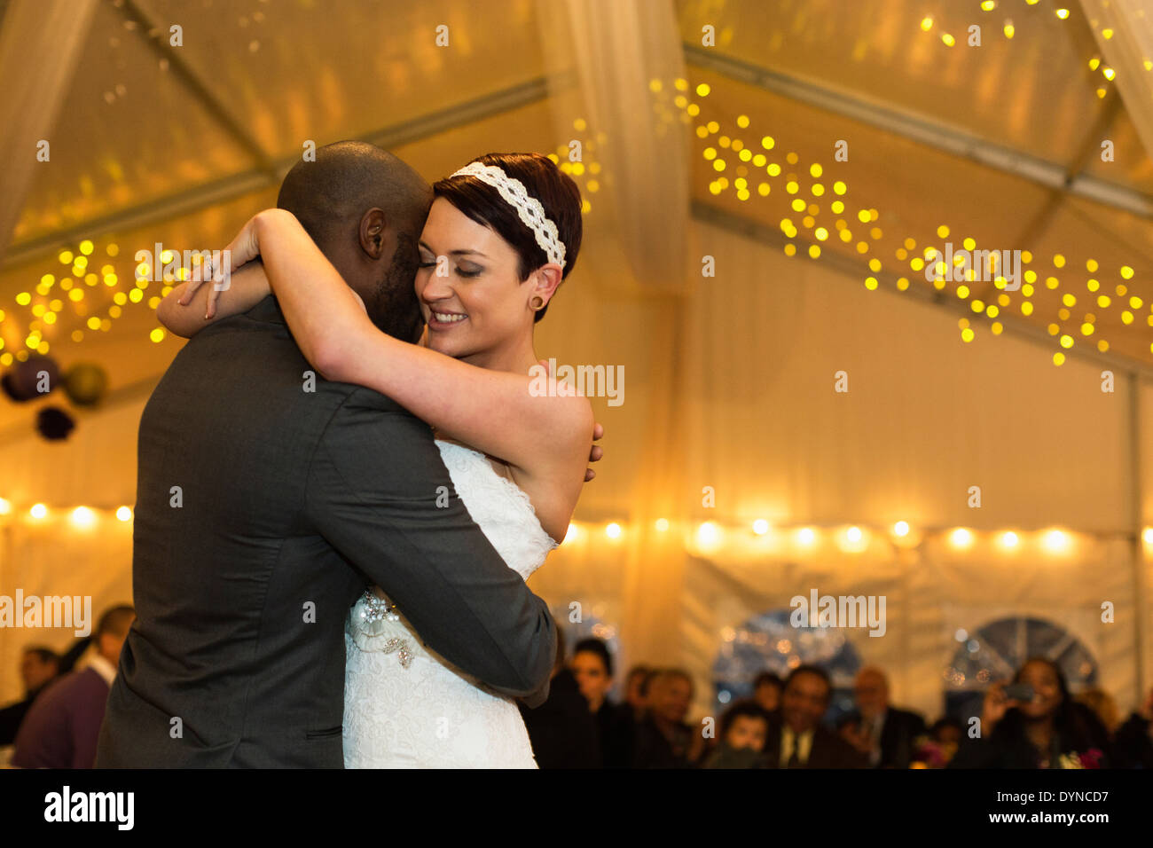 Newlywed couple dancing at reception Stock Photo