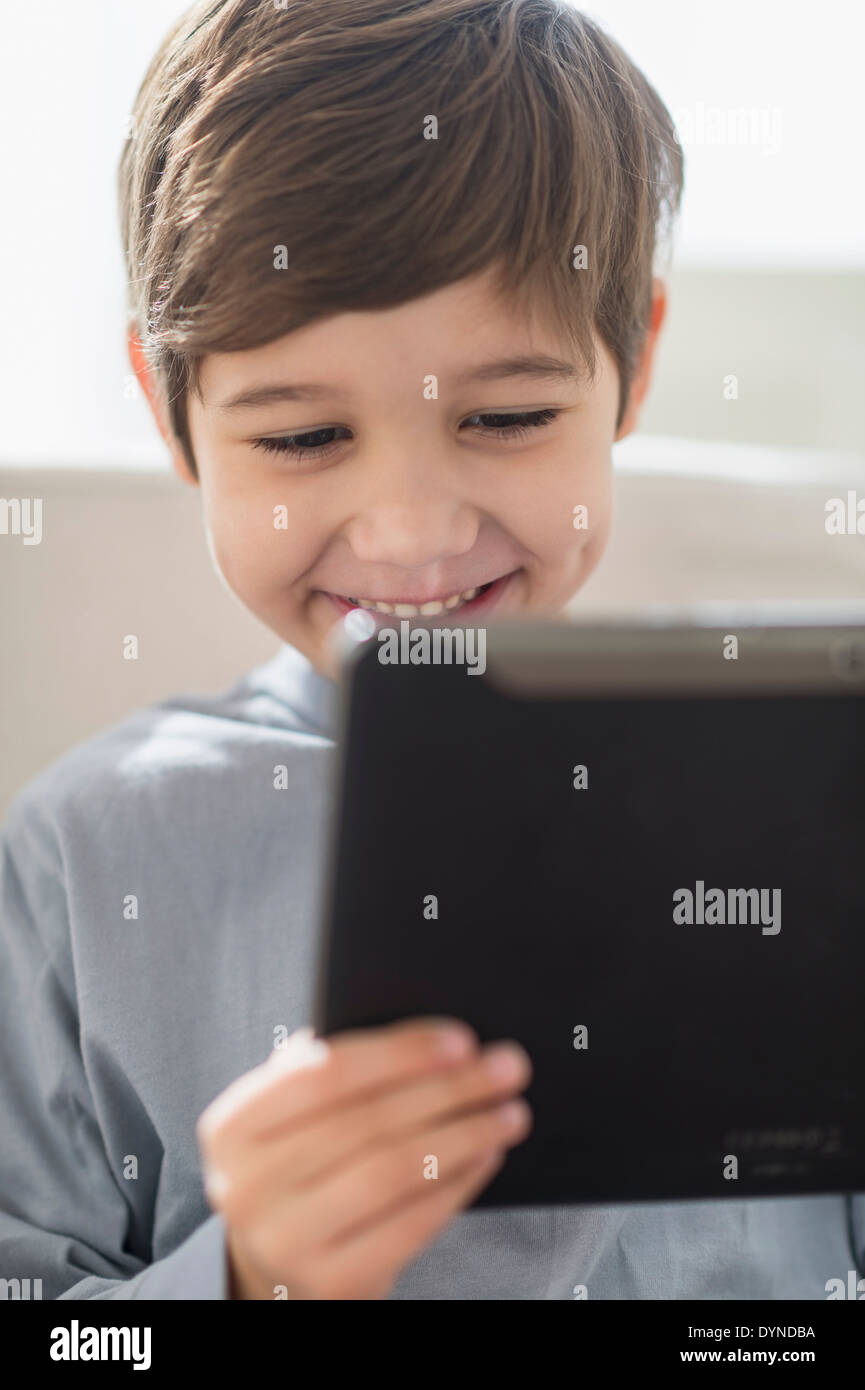 Hispanic boy using digital tablet on sofa Stock Photo