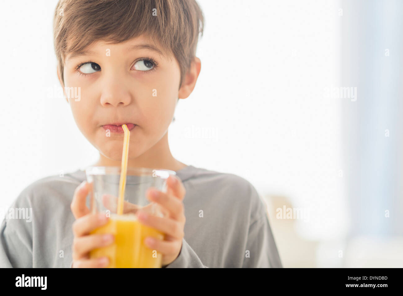 Hispanic boy drinking juice with straw Stock Photo