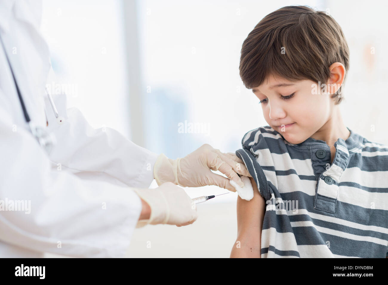 Hispanic boy getting a shot at doctor's office Stock Photo