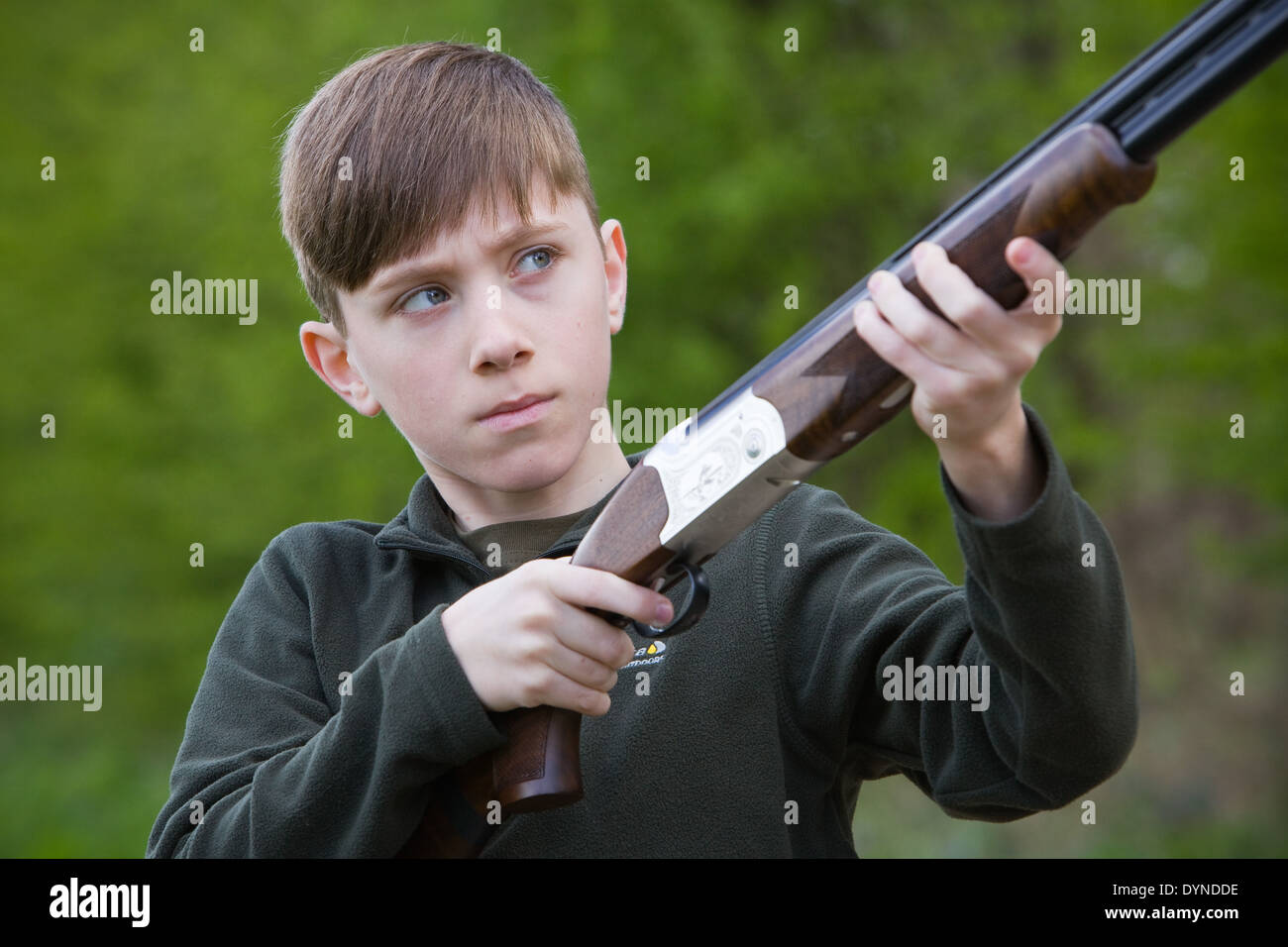 A young boy out in the English countryside with a shotgun Stock Photo