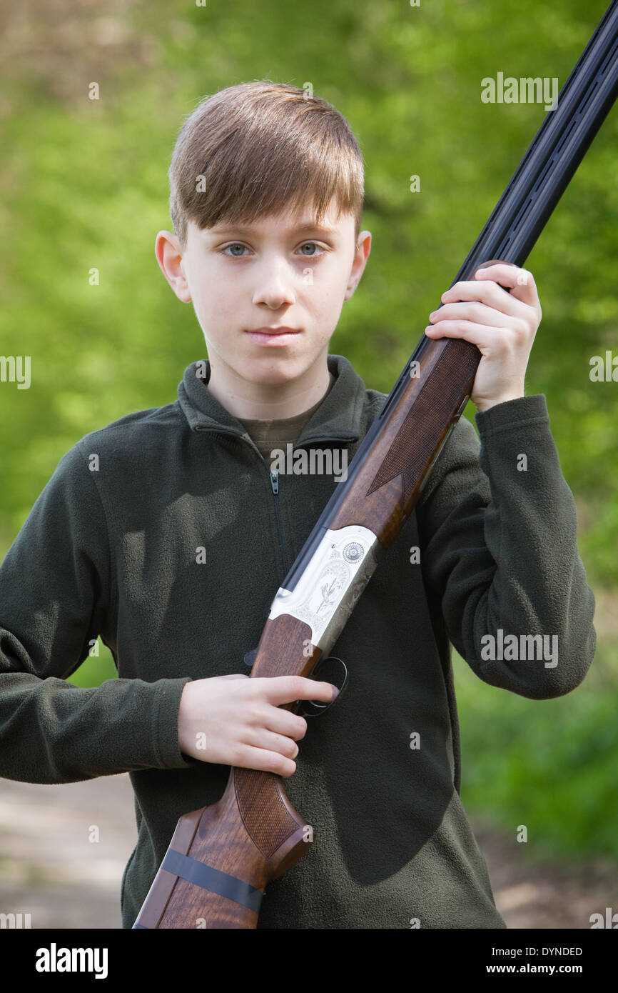 A young boy out in the English countryside with a shotgun Stock Photo