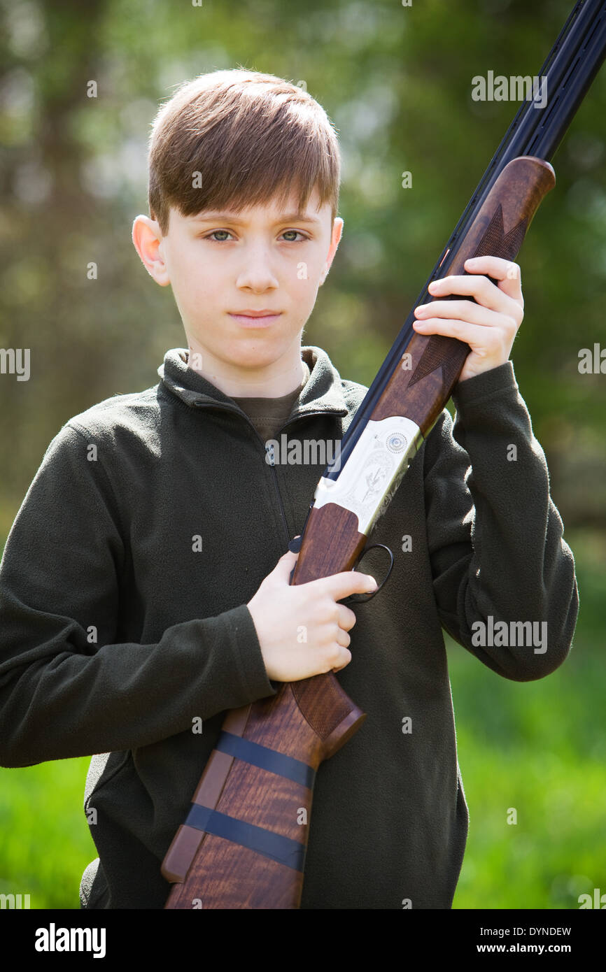 A young boy out in the English countryside with a shotgun Stock Photo