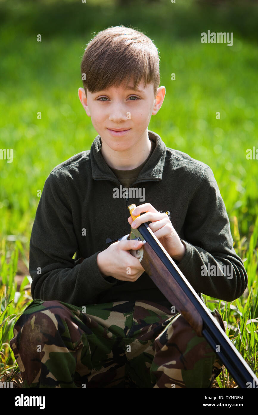 A young boy out in the English countryside with a shotgun Stock Photo