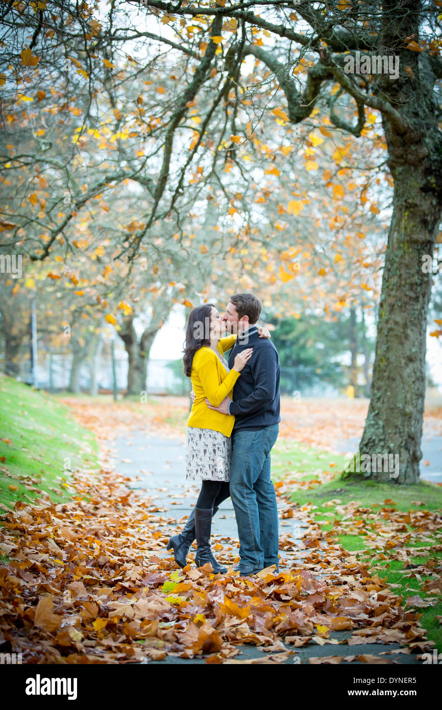 Caucasian couple kissing in park Stock Photo