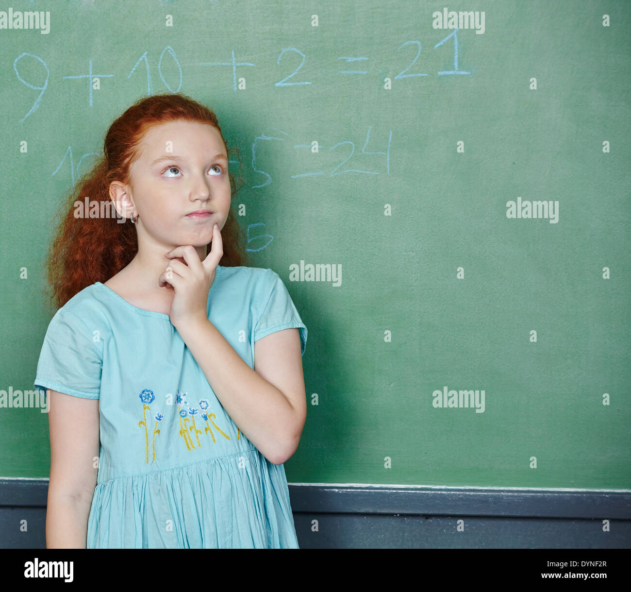 Pensive girl solving math problem in elementary school class Stock Photo