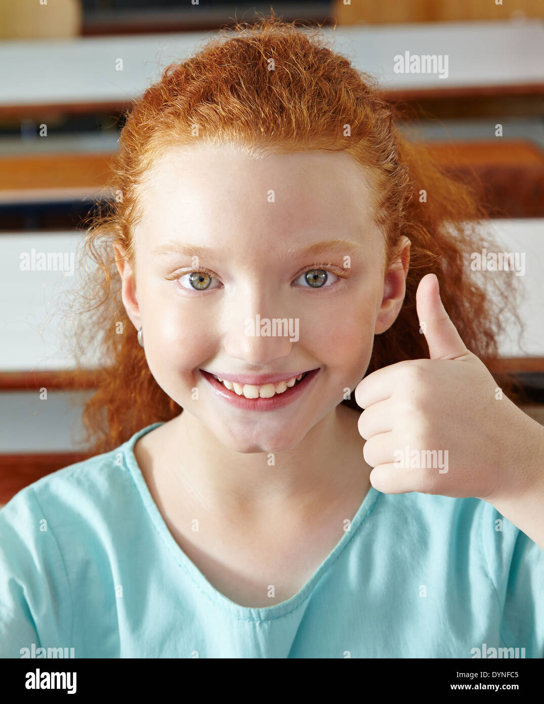 Happy girl in elementary school holding her thumbs up Stock Photo - Alamy