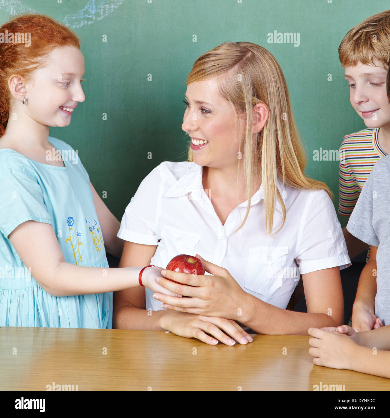 Student bringing teacher an apple in elementary school Stock Photo Alamy