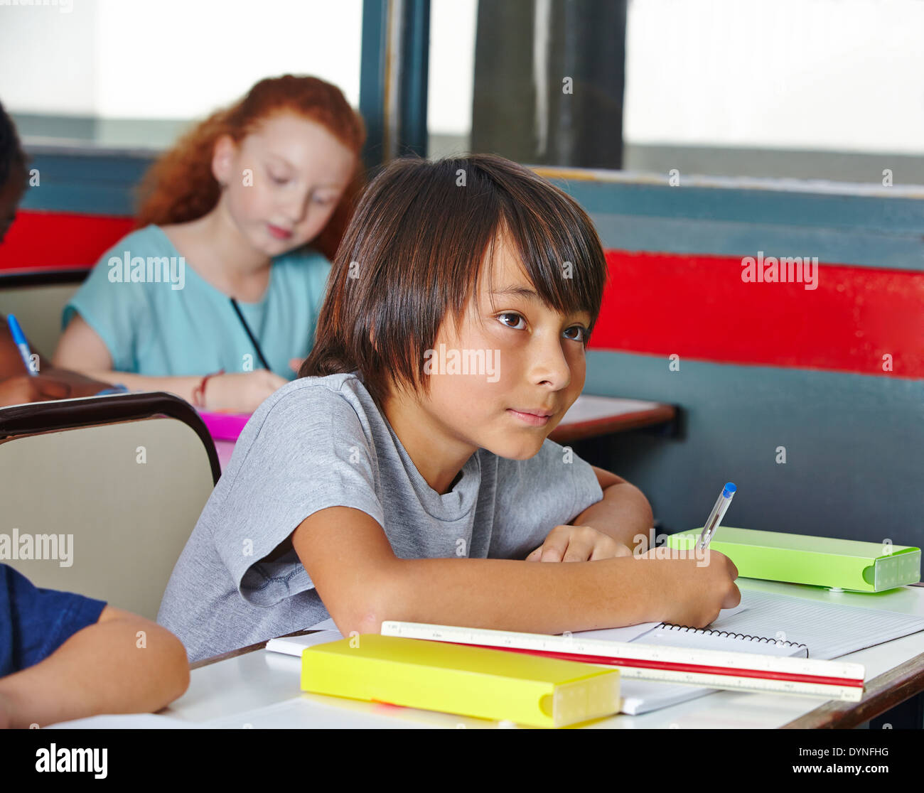Some students writing a pop quiz in elementary school class Stock Photo