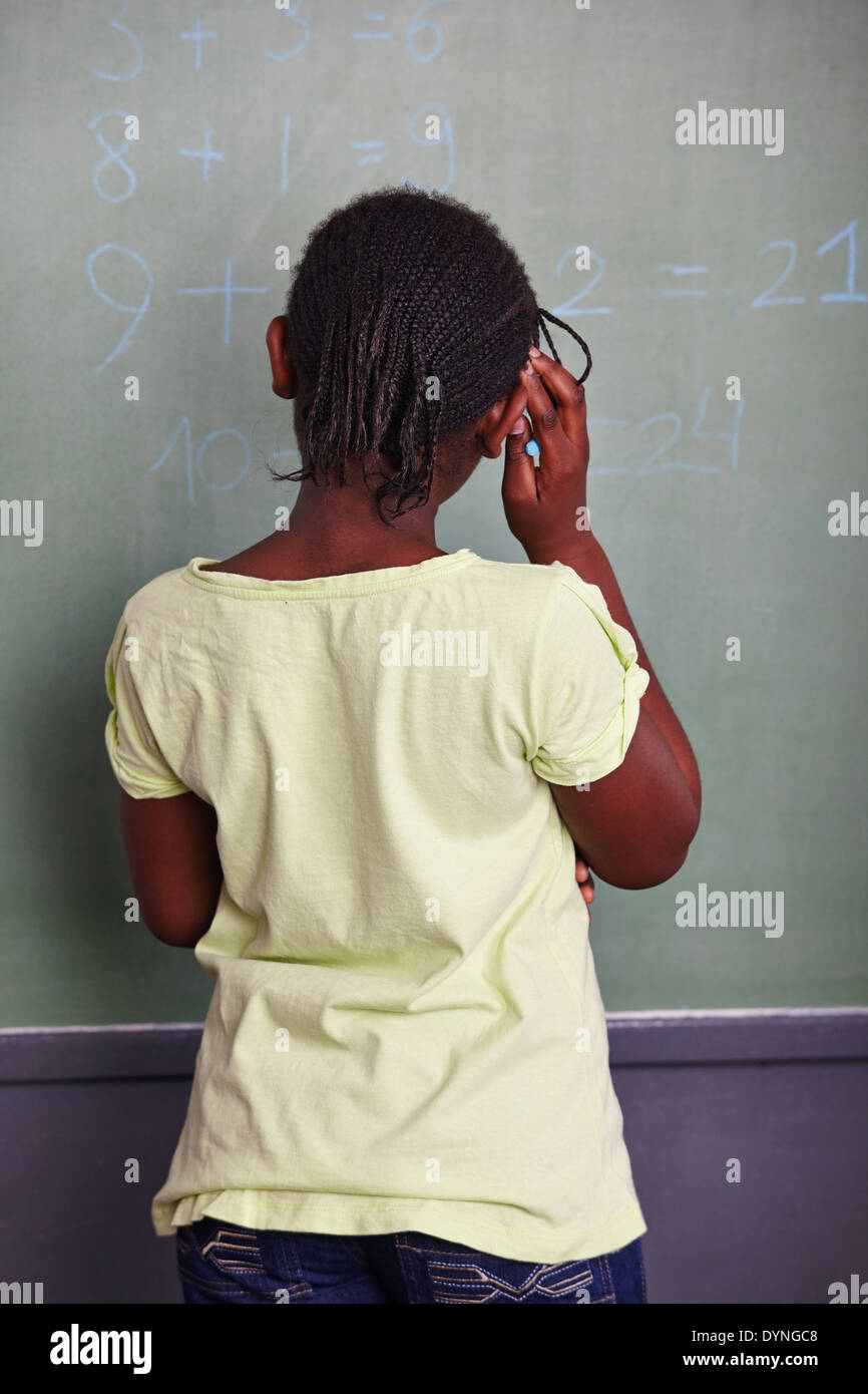 African girl solving math problem at blackboard in school Stock Photo