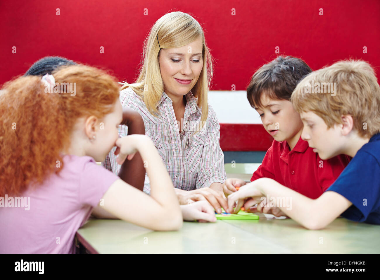 Students playing with teacher in elementary school class Stock Photo