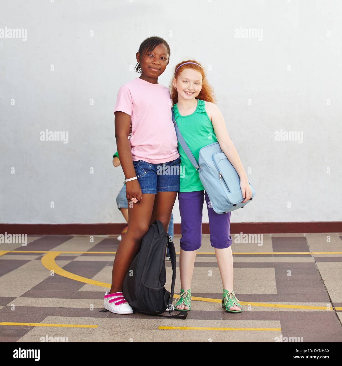 Two happy girls on schoolyard in elementary school Stock Photo