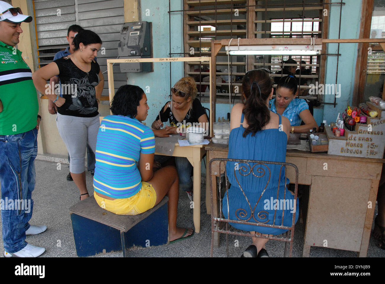 Outdoor nail bar in the city of Holguin, Cuba, with two customers being attended to. Stock Photo