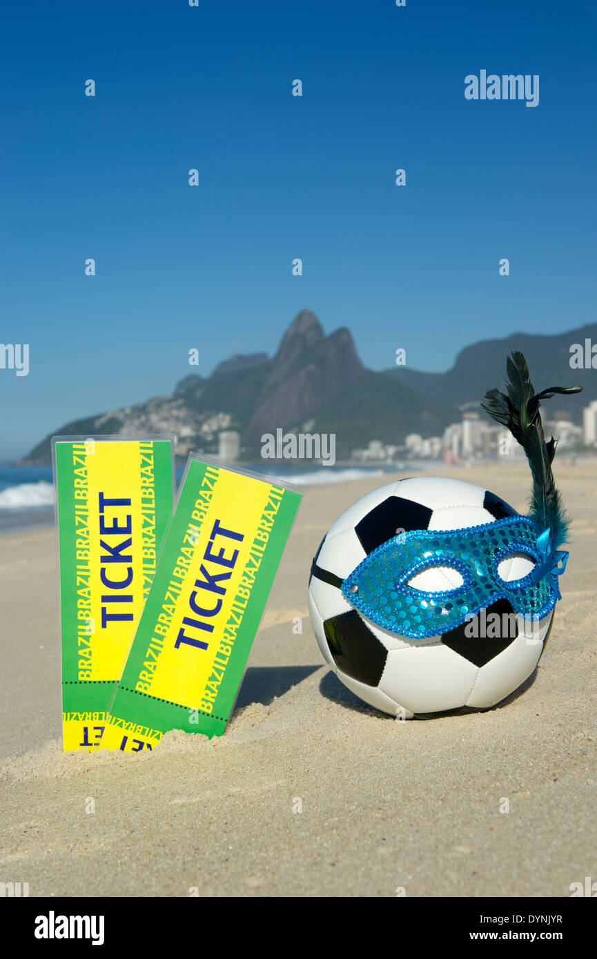 Brazil tickets stand next to soccer theme Rio Carnival football wearing sparkly mask on Ipanema Beach Stock Photo