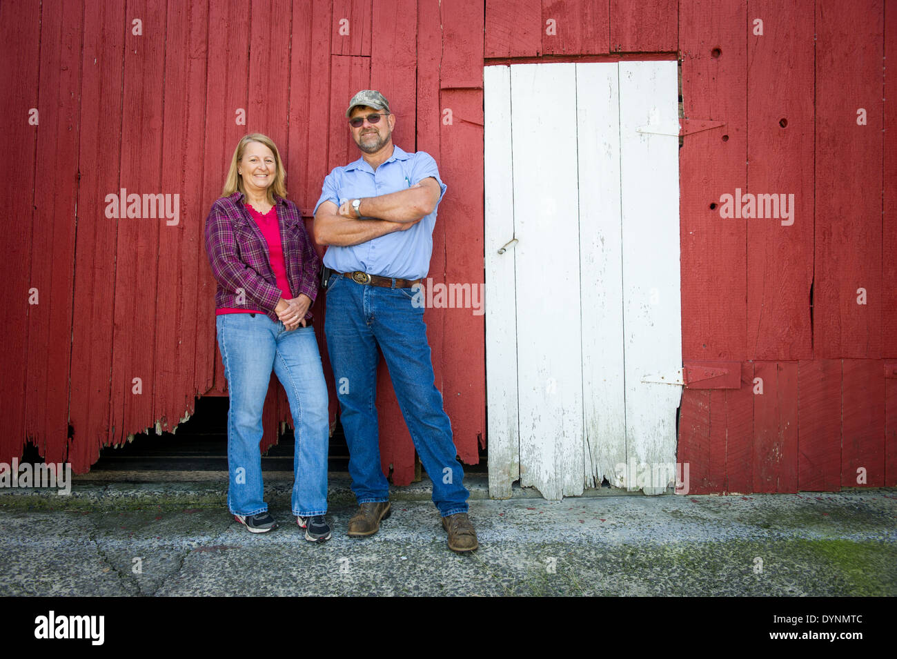 Husband and wife farmers standing in front of a red barn Gettysburg PA Stock Photo
