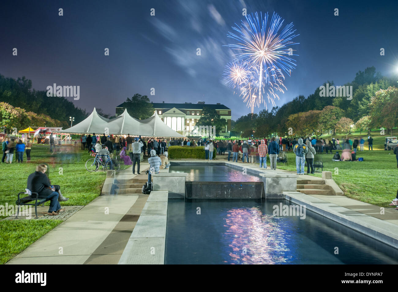 Fireworks above college students at a party and pep rally in