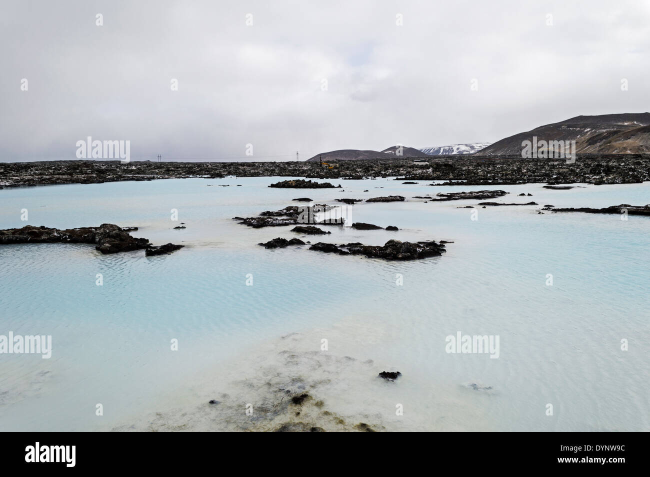 warm water in blue lagoon iceland with mountains with snow as