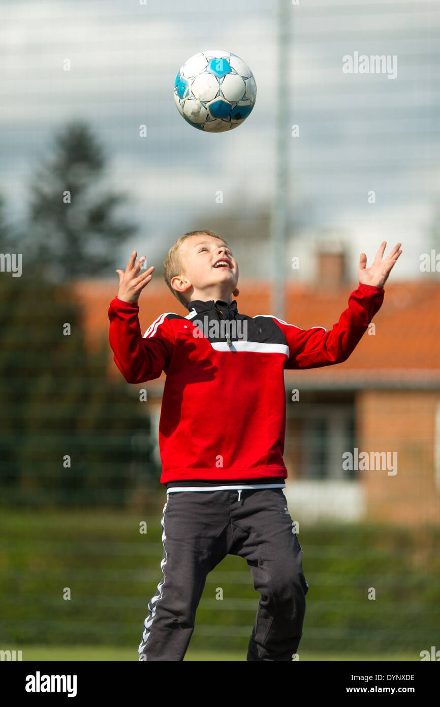 Young caucasian boy having fun with his soccer ball. Trademarks have