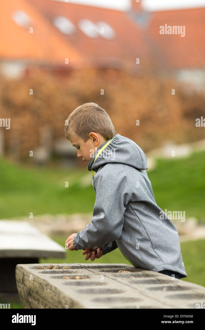 Young caucasian boy playing a game of mancala with himself. Stock Photo