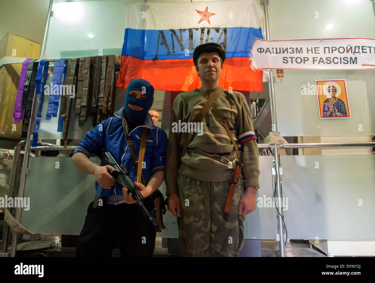 Lugansk, Ukraine. 23rd Apr, 2014. Pro-Russian gunmen guard an entrance of the Ukrainian regional office of the Security Service with a Russian National flag is in background --- Armed pro-Russian militants holed up in the the Ukrainian regional office of the Security Service in Luhansk and refused to give up their arms and vowed to fight. Credit:  Igor Golovnov/Alamy Live News Stock Photo