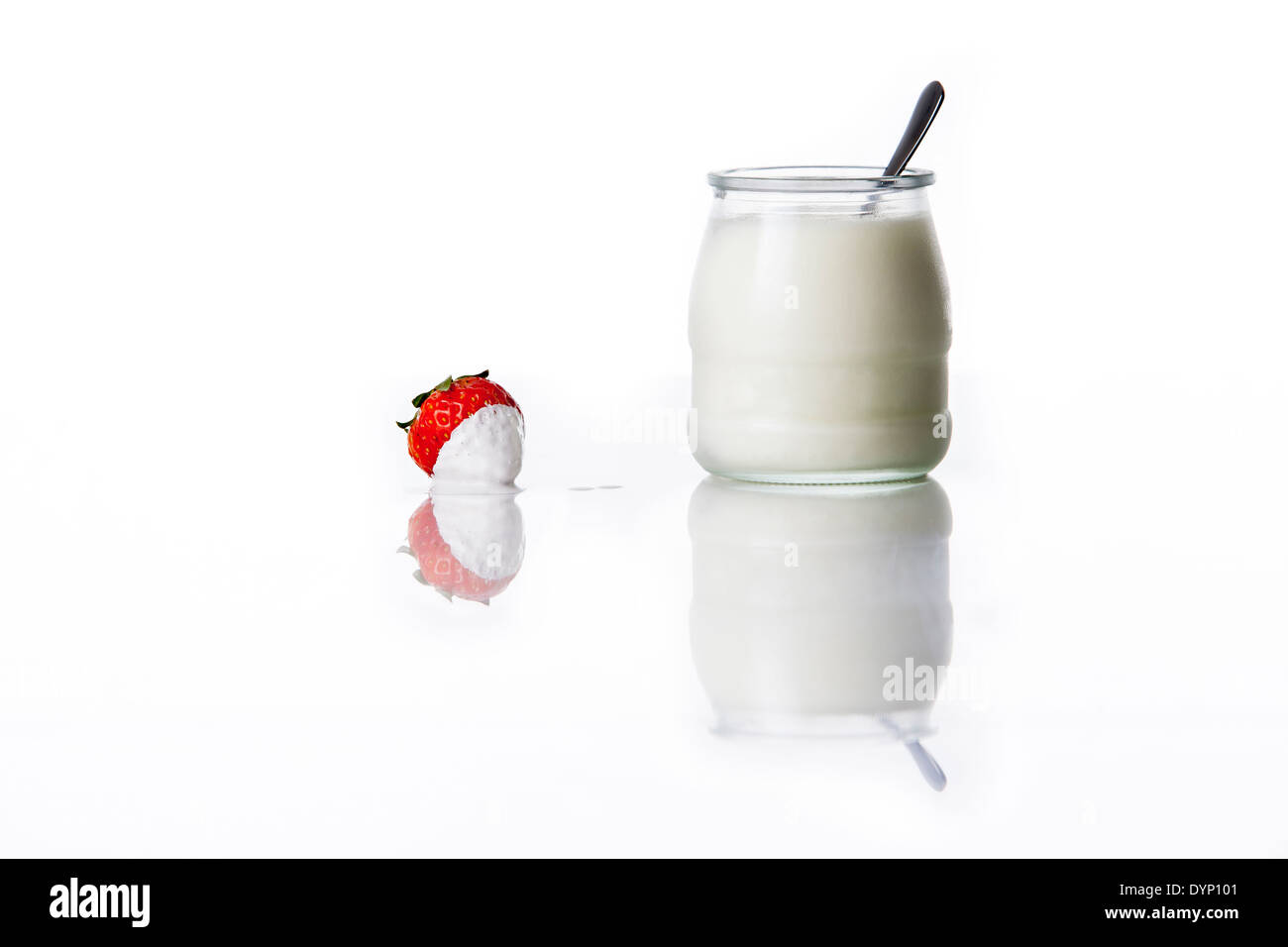 Yogurt in a jar with strawberries on a white table Stock Photo