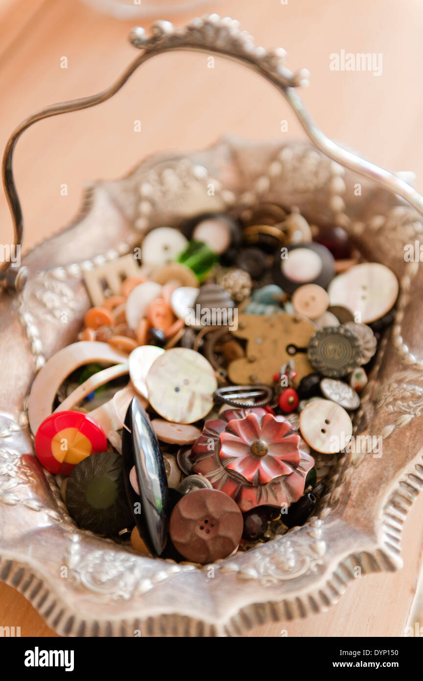 Assorted buttons in an ornate silver basket Stock Photo