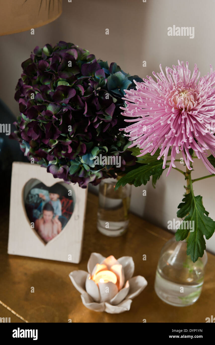 Lotus flower tea light holder on surface with hydrangea flower and pink